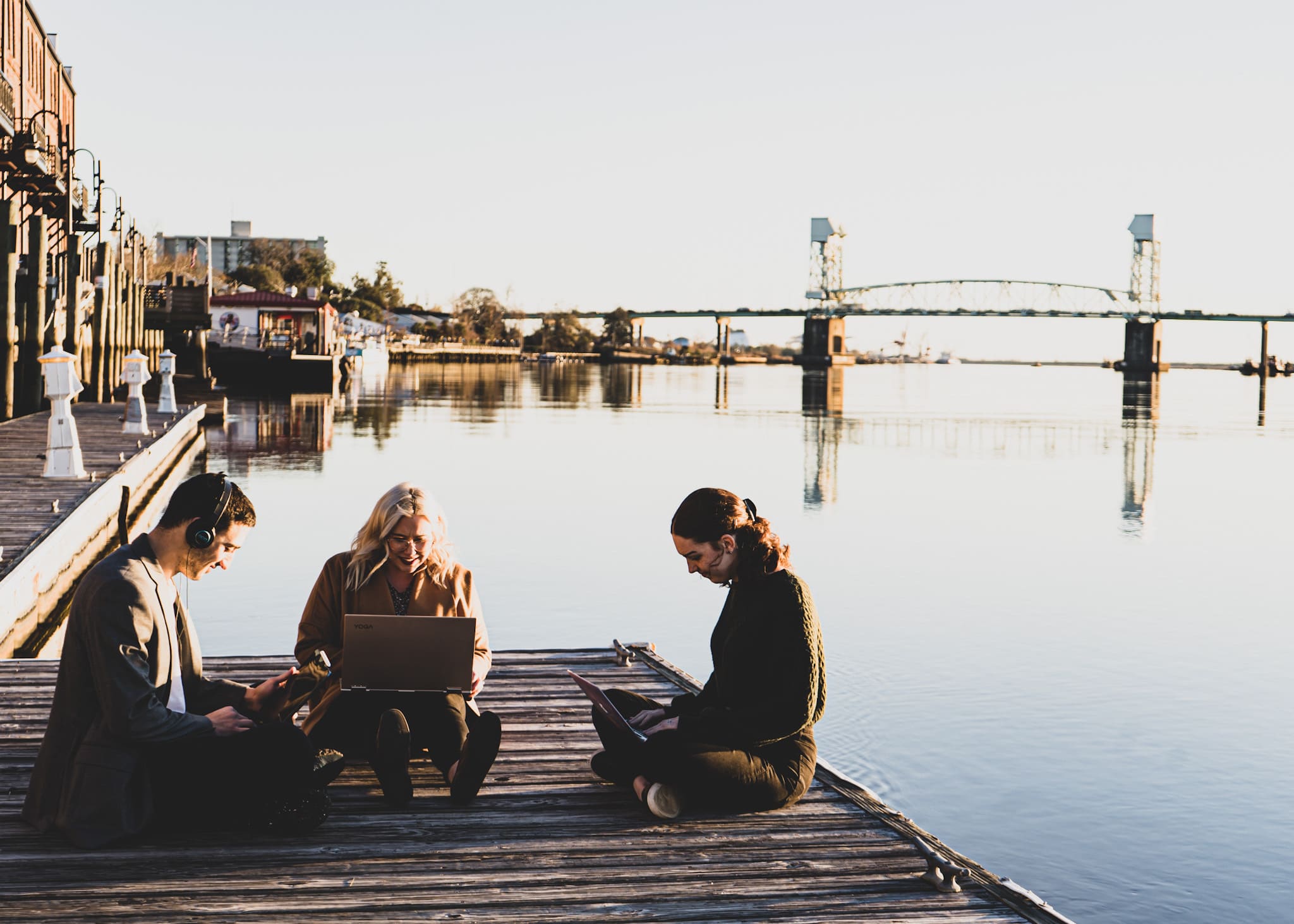 Three DesignLoud team members working on laptops on the Wilmington riverfront