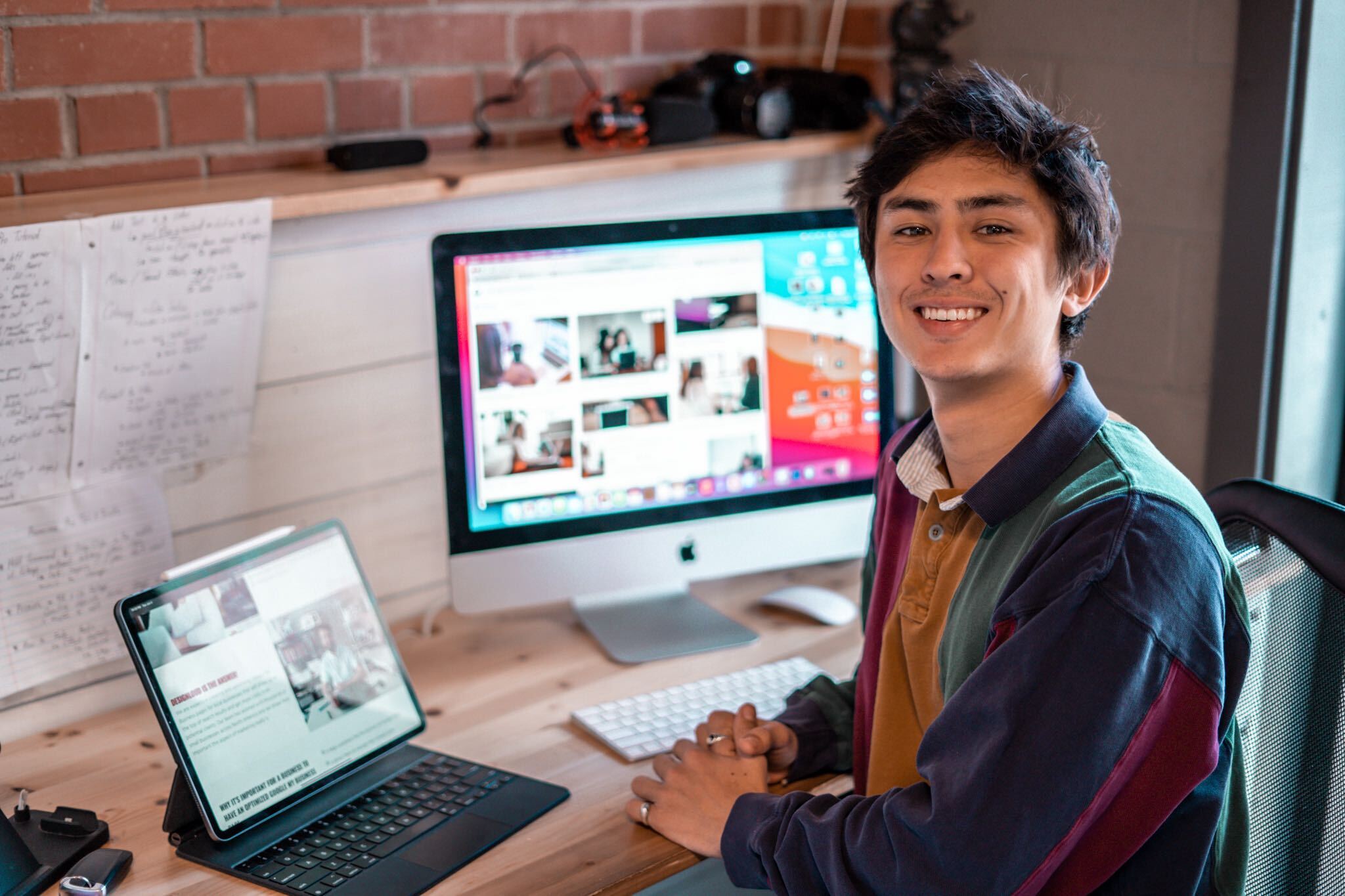 A DesignLoud team member at his desk in the brick-walled Wilmington office