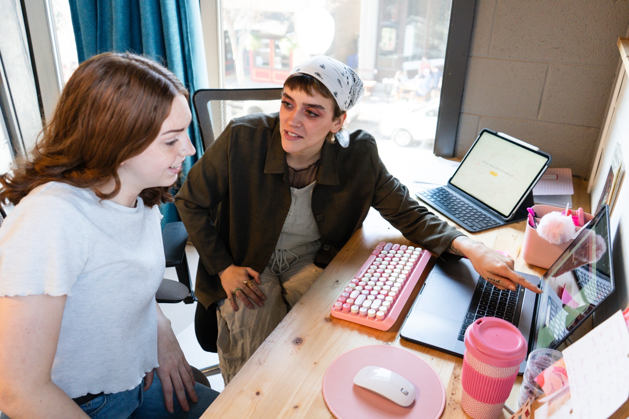 Two DesignLoud team members reviewing work together at a laptop